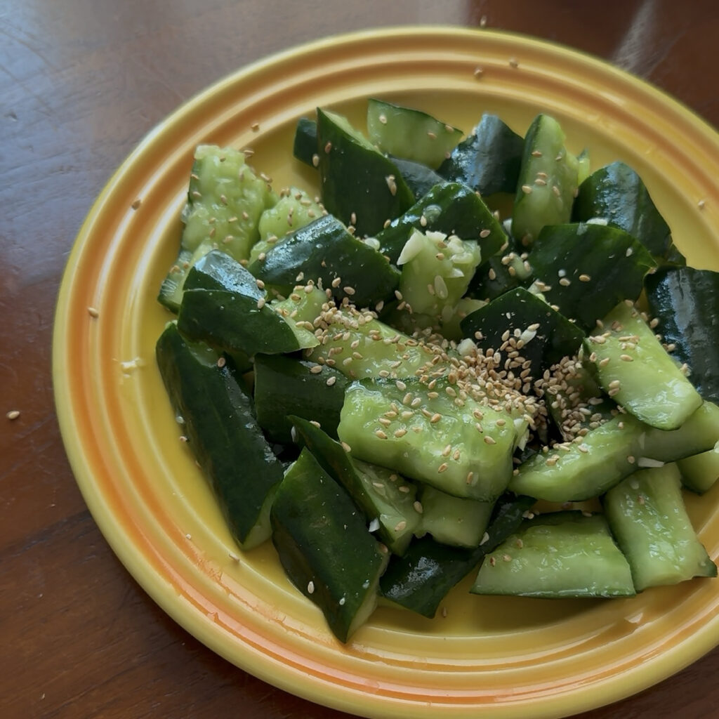 Smashed Cucumber Salad Sprinkling sesame seeds on Korean smashed cucumber salad