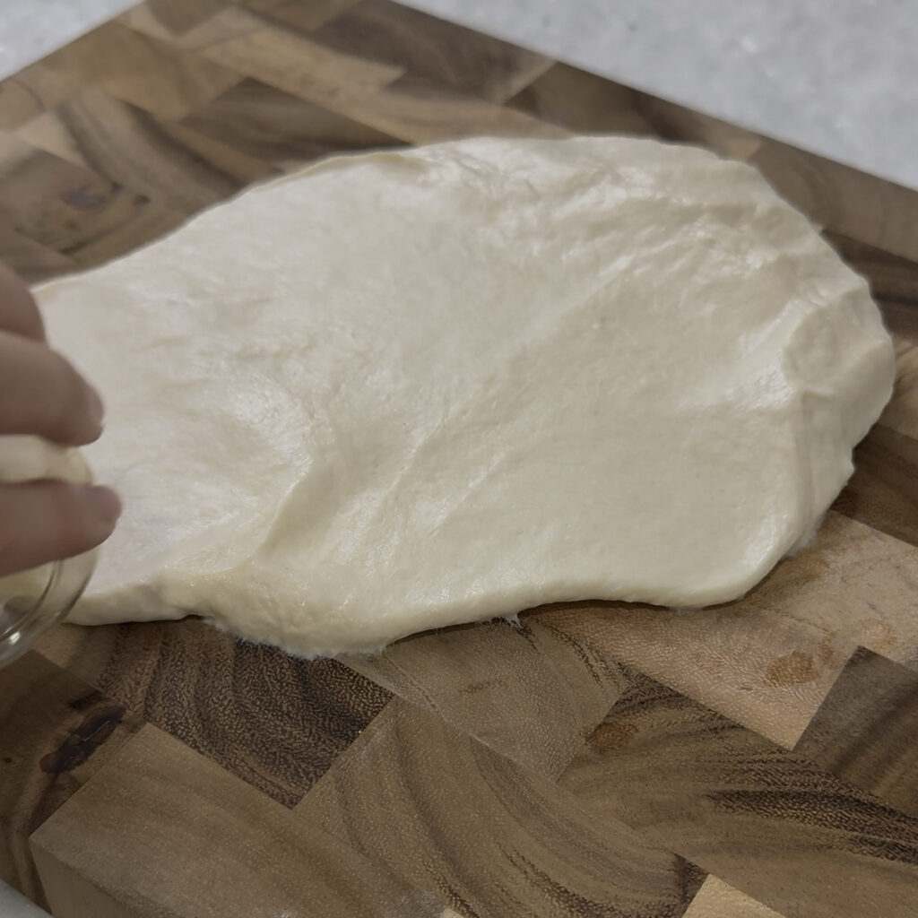 Sujebi Rolling out Korean sujebi dough with a rolling pin