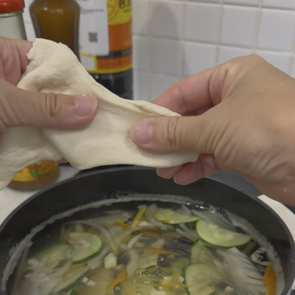 Sujebi Hand tearing Korean sujebi dough into pieces