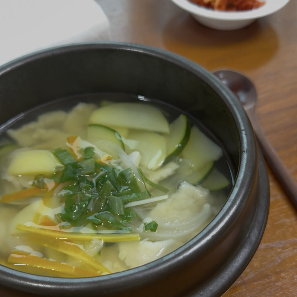 Sujebi Adding chopped green onions on top of Korean sujebi soup