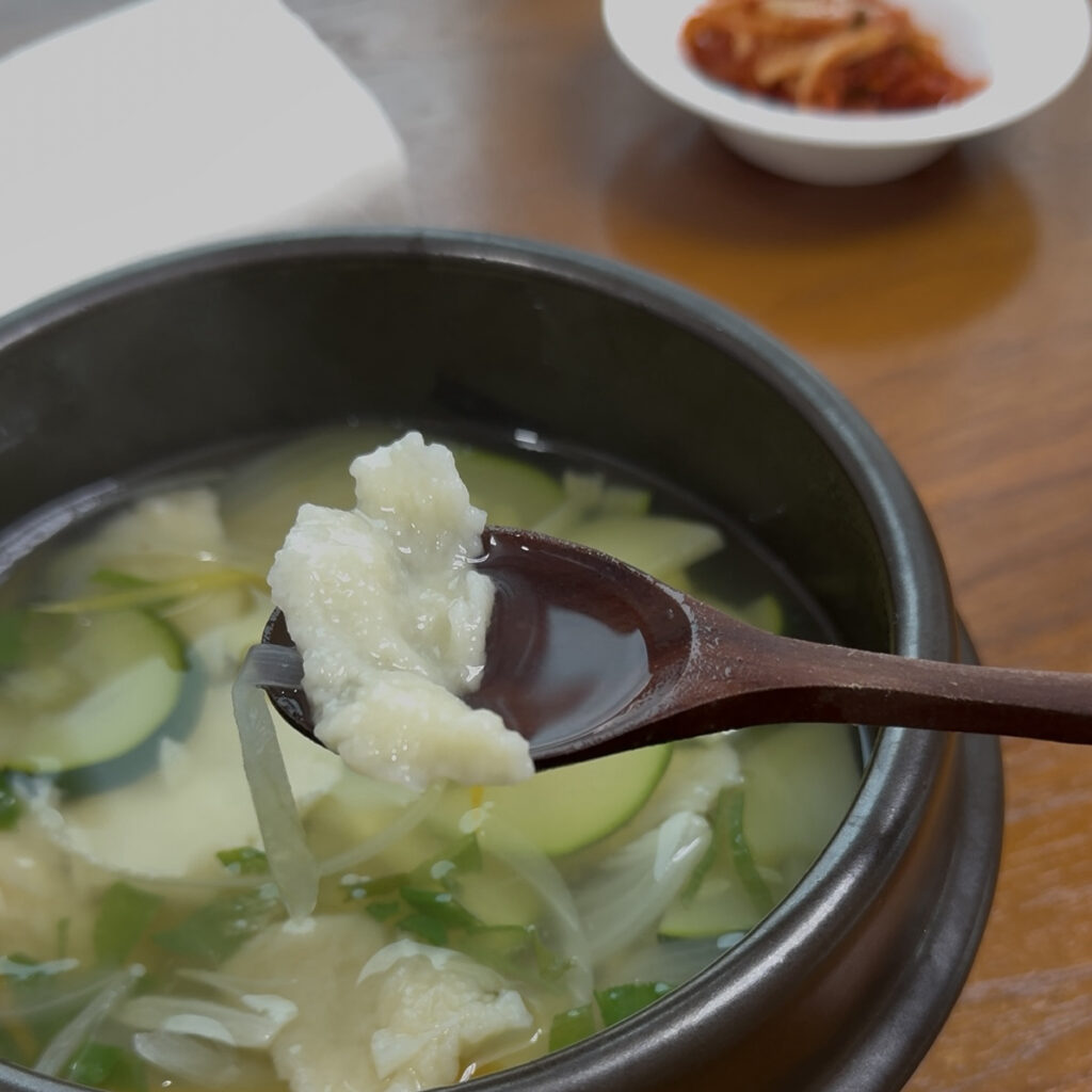 Sujebi Scooping Korean sujebi soup with a spoon