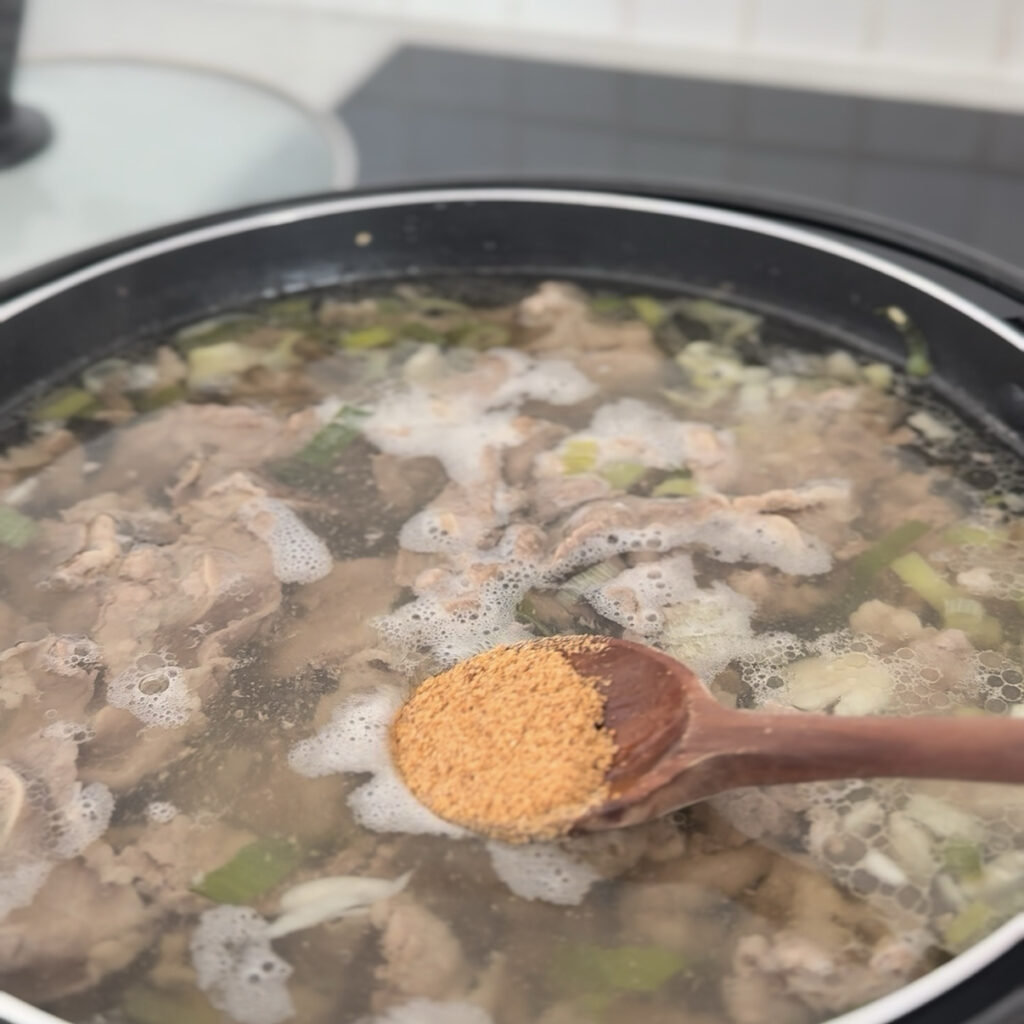 Adding water and beef bouillon to the pot