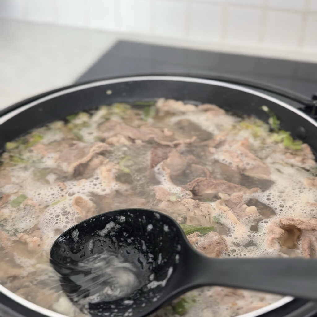 Skimming the fat from the broth