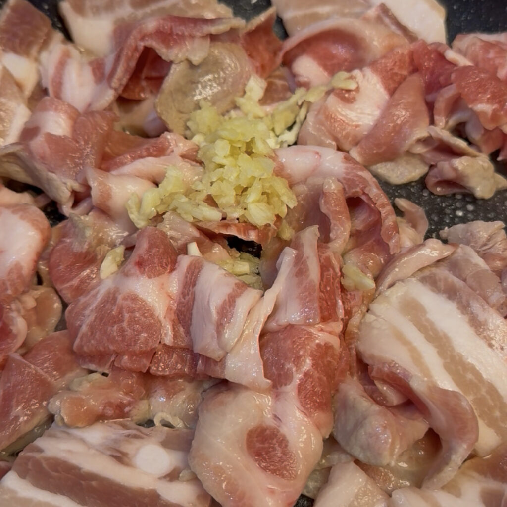Pork and garlic cooking in a pan