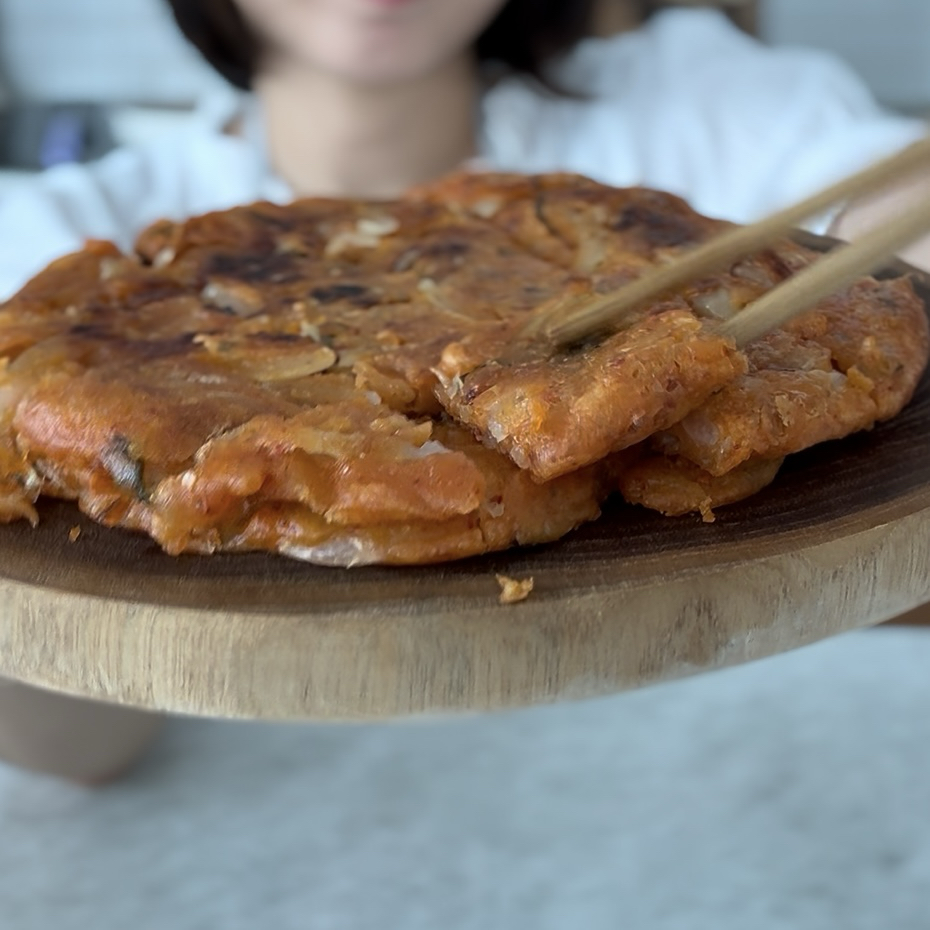 Crispy sour kimchi pancakes served on a wooden plate