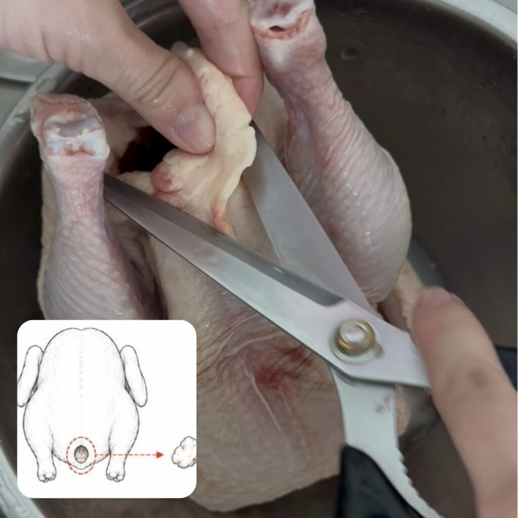 Trimming excess fat inside the tail cavity of a whole chicken.