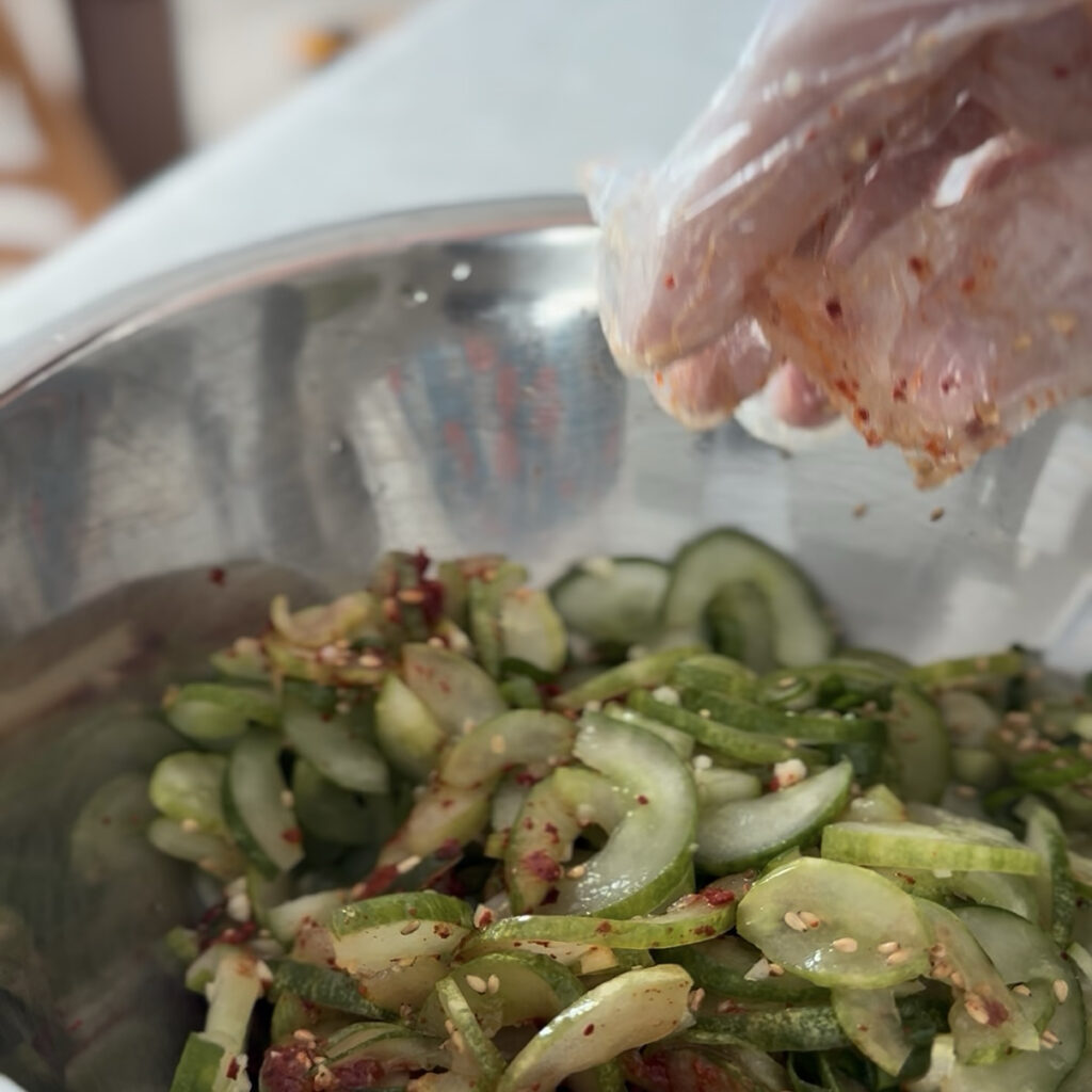 Tossing cucumbers with Korean seasoning