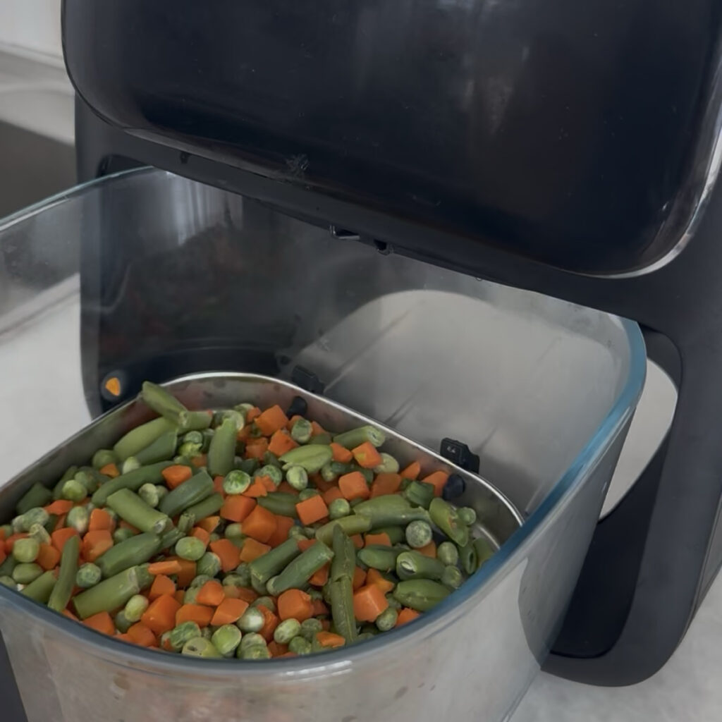 Vegetables spread evenly in an air fryer basket