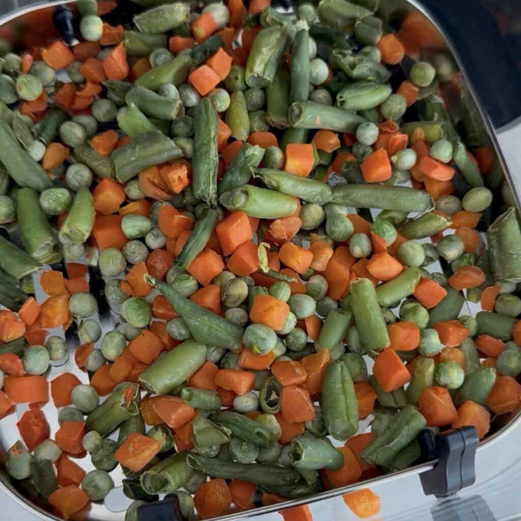 Frozen vegetables in an air fryer basket