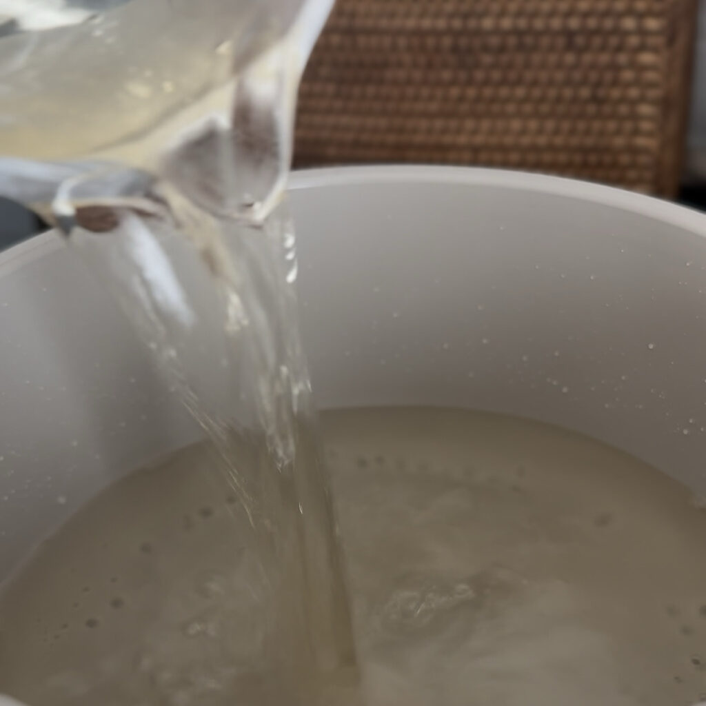 Adding white vinegar to the hot pickling liquid.