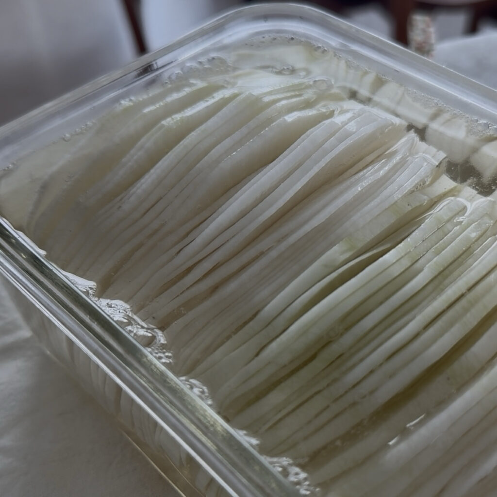 Homemade Korean pickled radish (ssammu) served in a glass container.