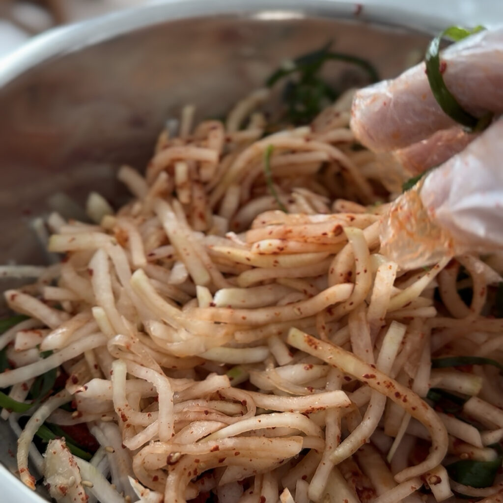 Mixing the daikon radish with Korean seasoning to make musaengchae.