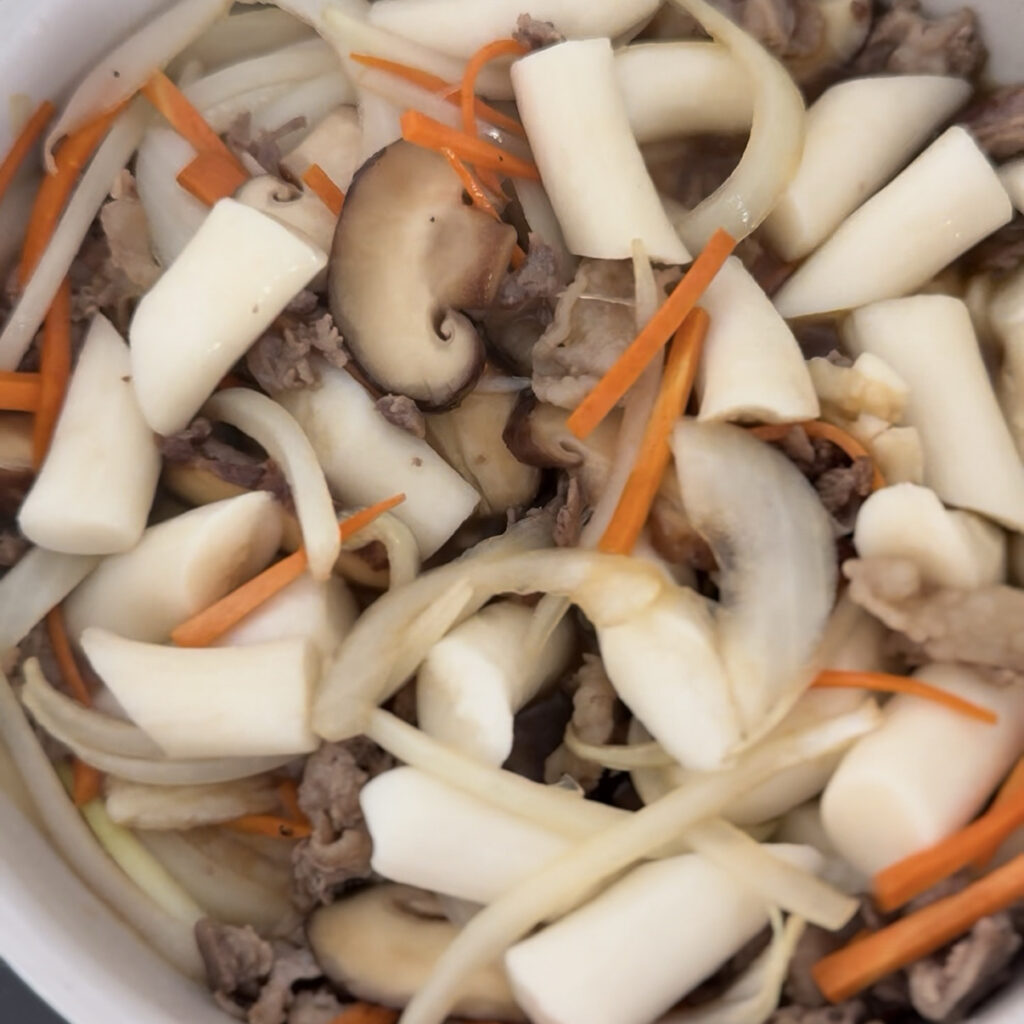 Adding Korean rice cakes to the pan