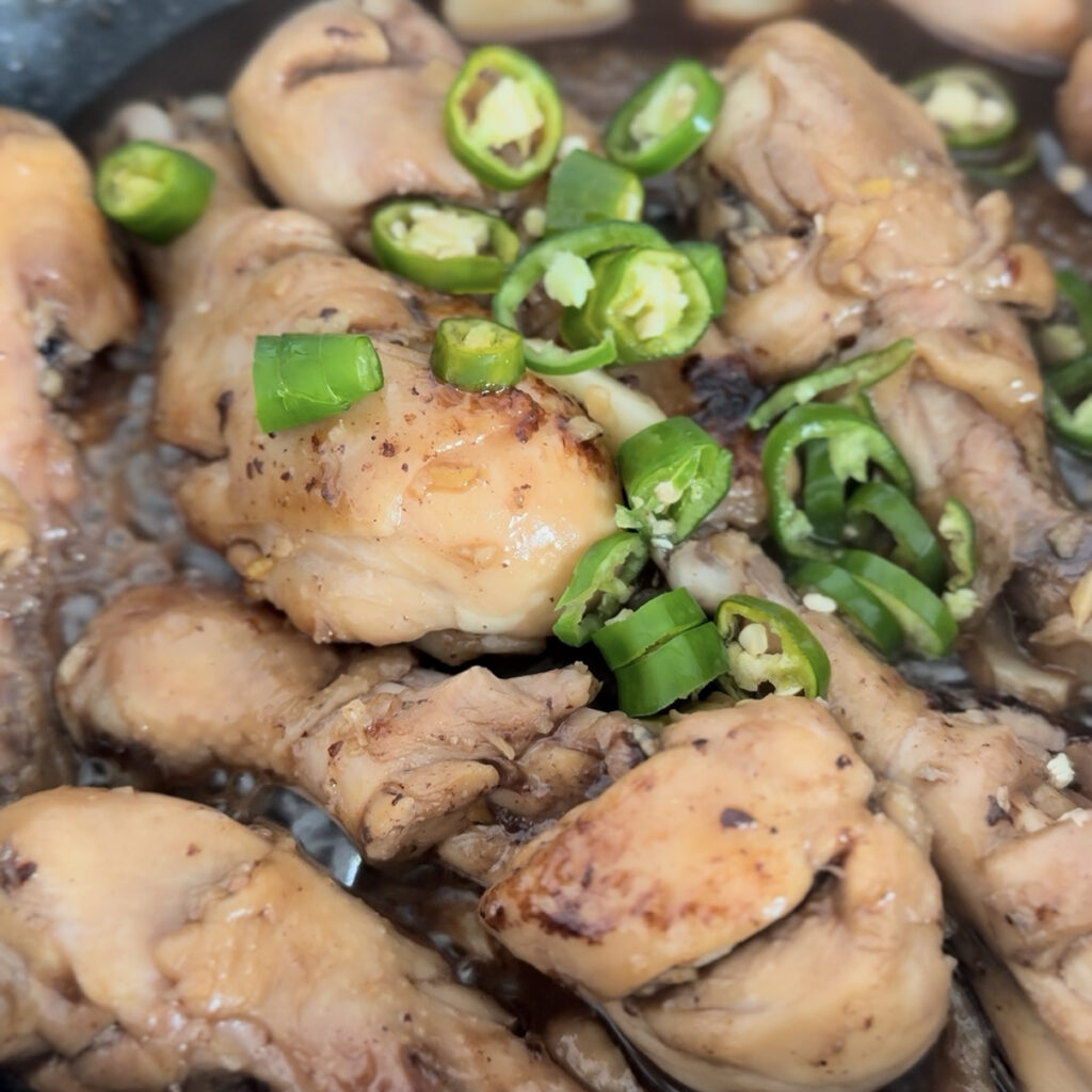 Green chili peppers added to braised chicken