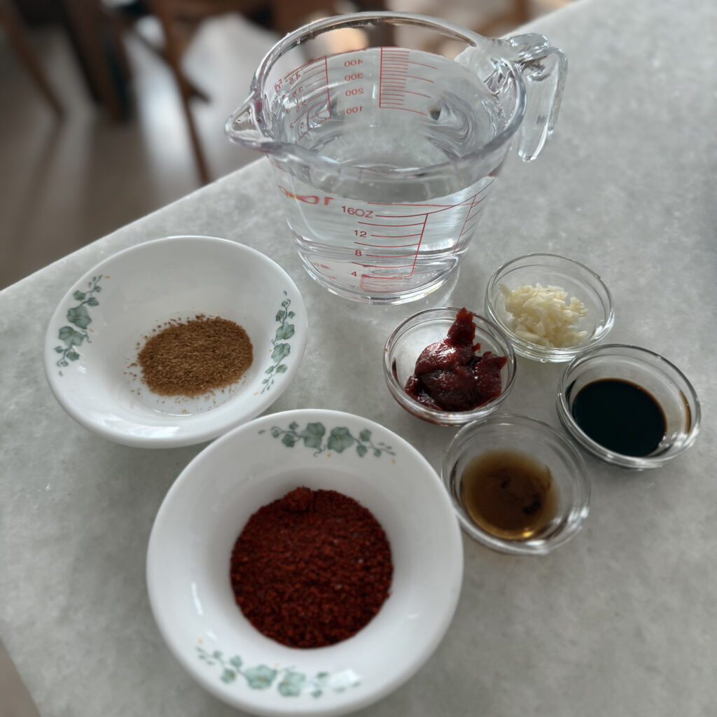 Spicy Korean broth ingredients measured and ready to mix for homemade shabu shabu.