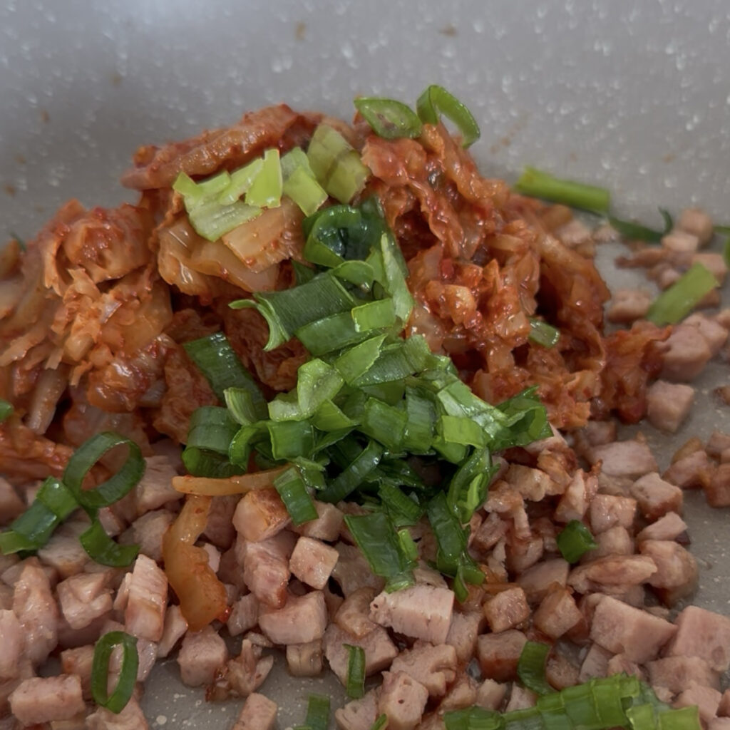 Spam and kimchi stir-fried with green onion, sugar, and gochugaru
