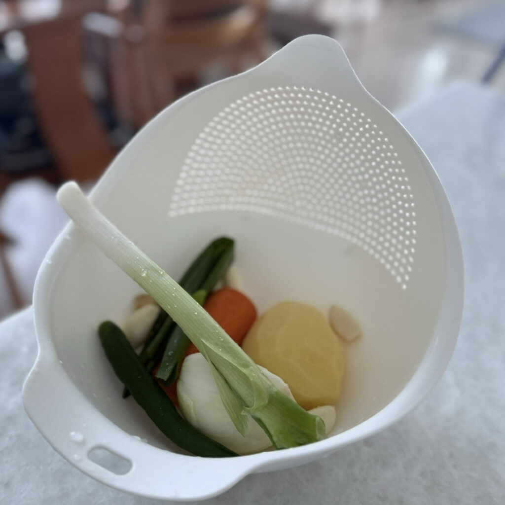 Fresh vegetables for Korean spicy chicken stew, including potatoes, carrots, green chili, and green onion.