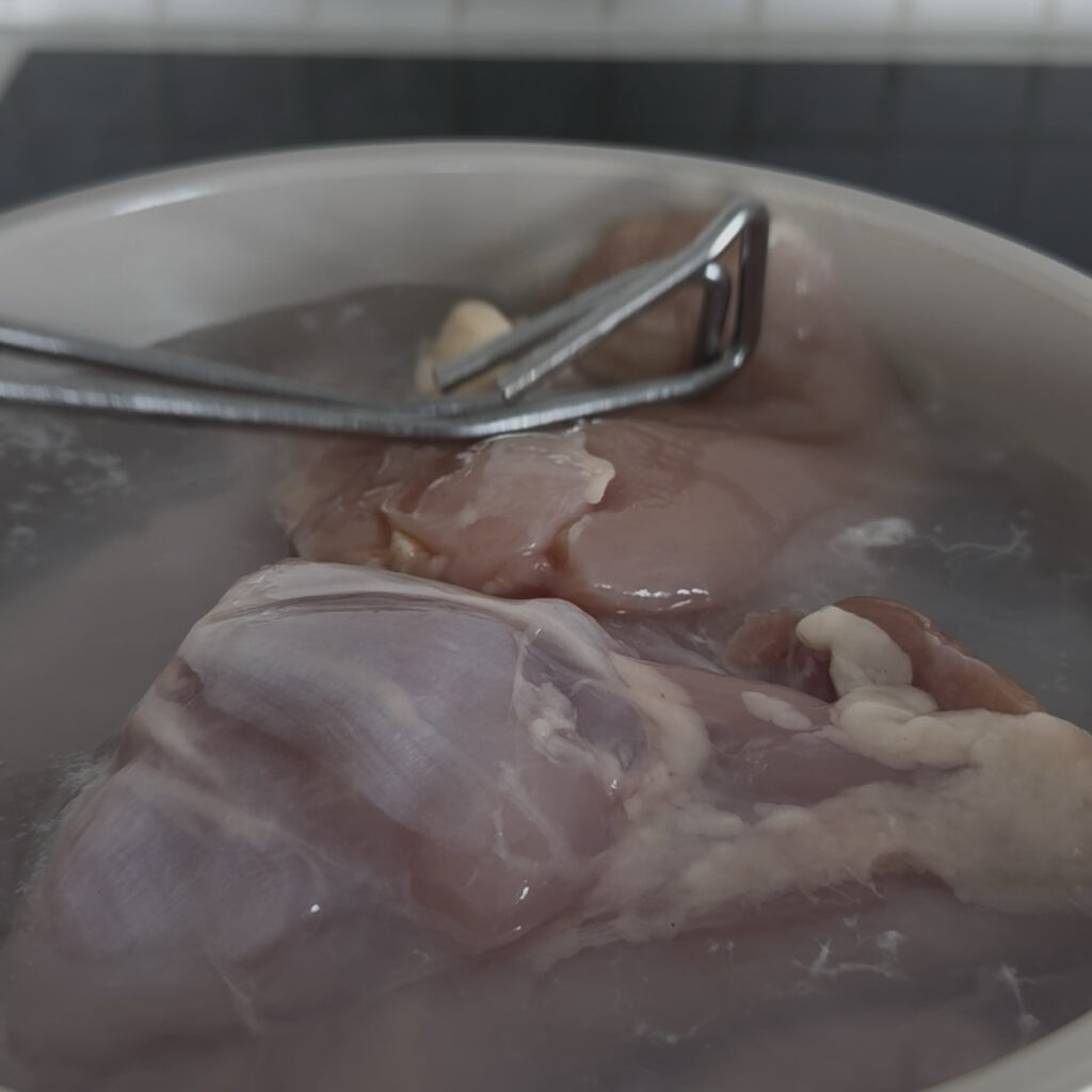 Chicken thighs being blanched before making Korean spicy chicken stew.