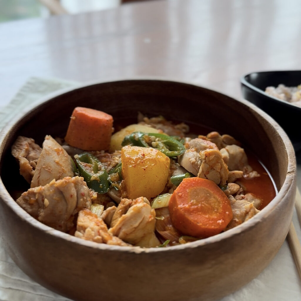 Korean spicy chicken stew with tender chicken, potatoes, carrots, and green chili.