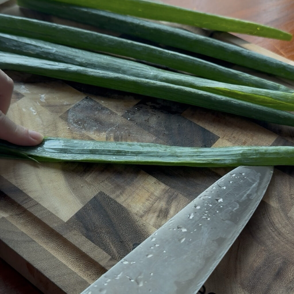 Cutting green onions lengthwise and opening the green parts
