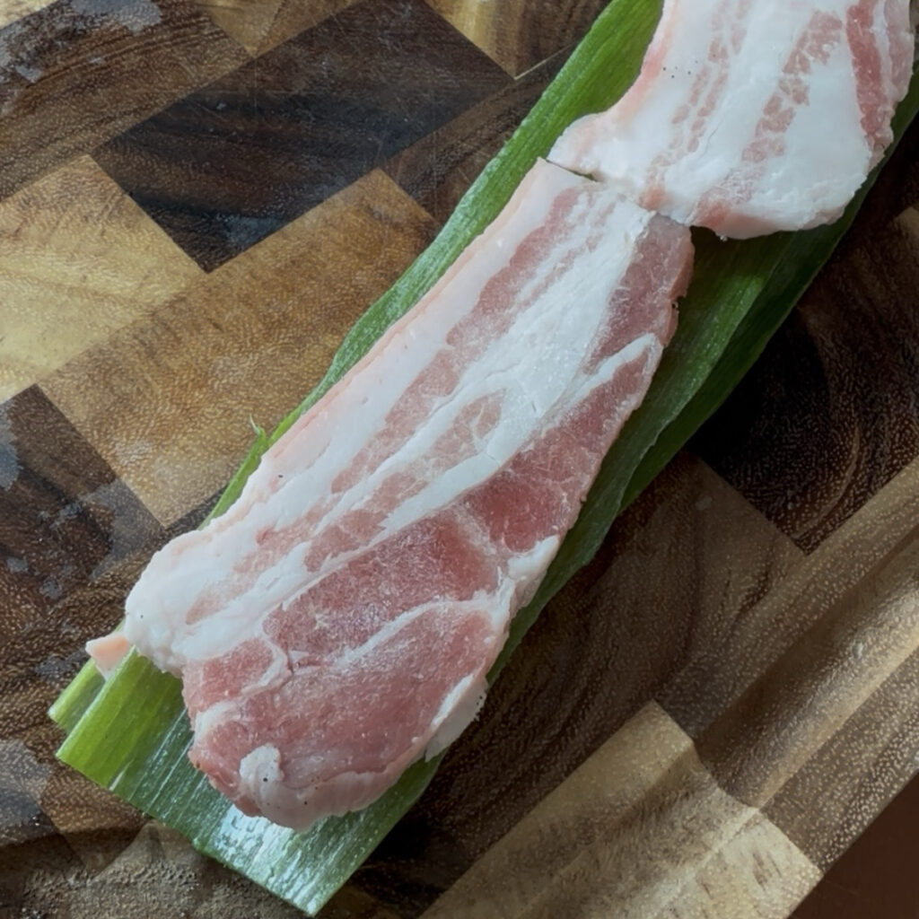 Layering seasoned pork belly with green onions