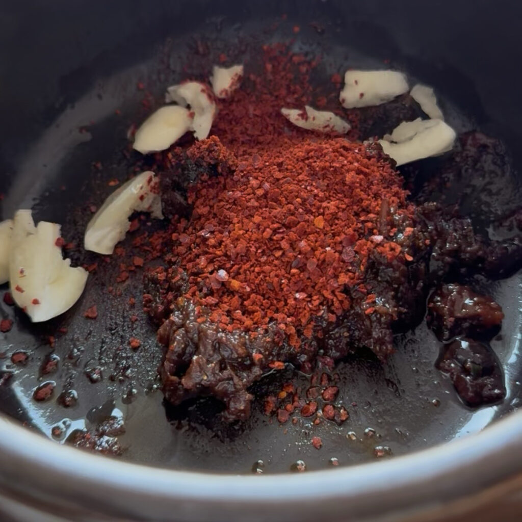 Doenjang and ssamjang with gochugaru and minced garlic in a Korean clay pot