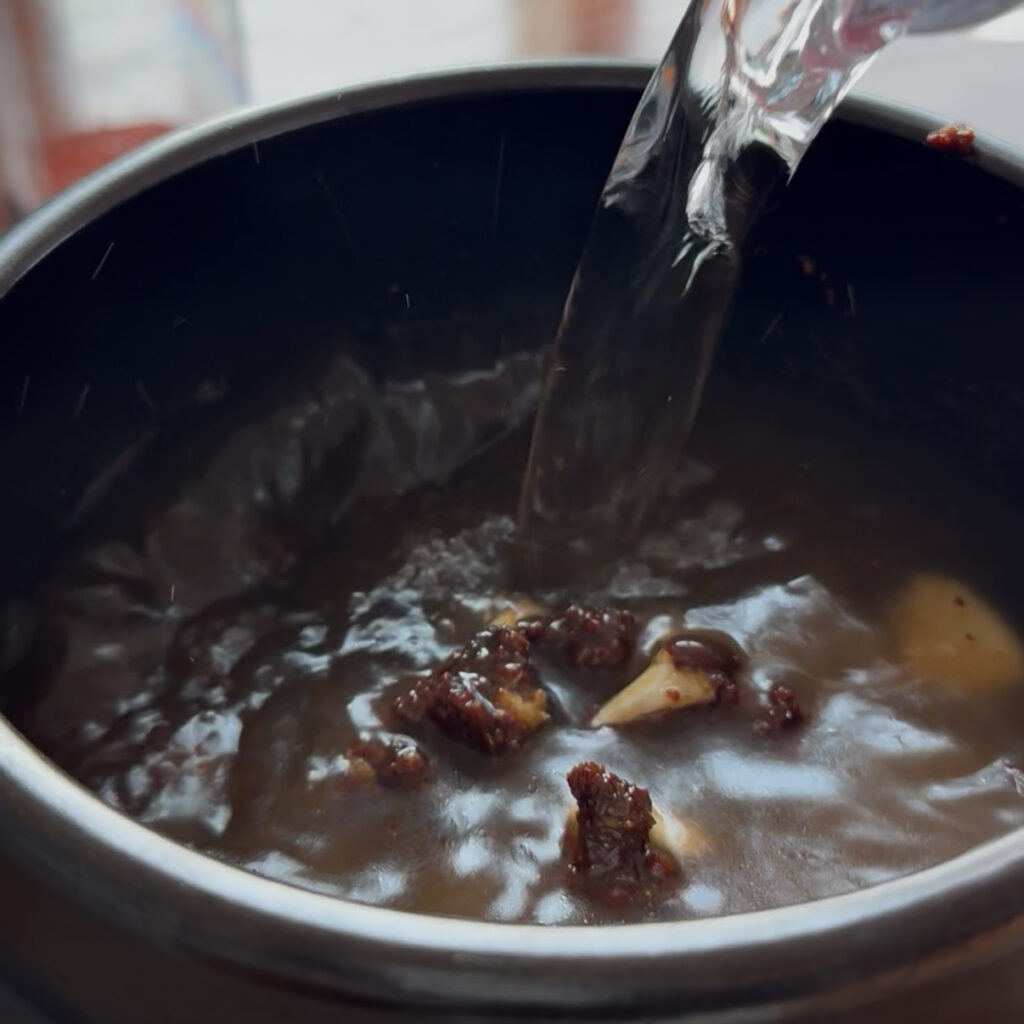 Adding water to doenjang and ssamjang mixture