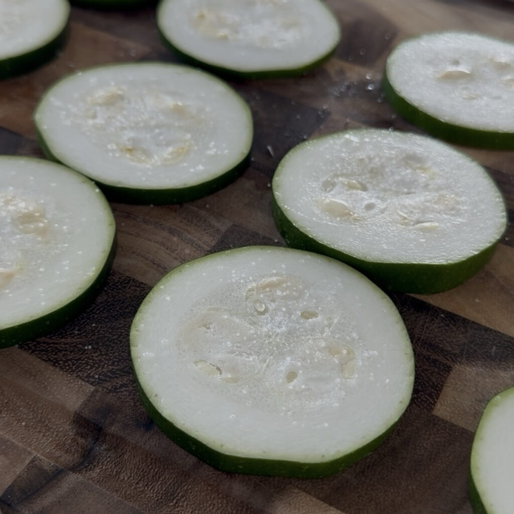 Zucchini slices resting with salt to remove excess moisture