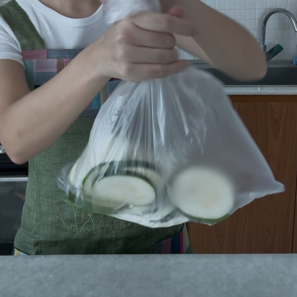 Coating zucchini slices lightly with all-purpose flour