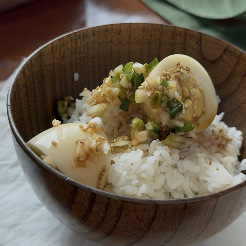 Korean soy-marinated eggs with marinated onions and green onions over rice