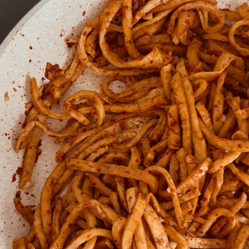Stir-frying thinly sliced Korean fish cake in a spicy sauce