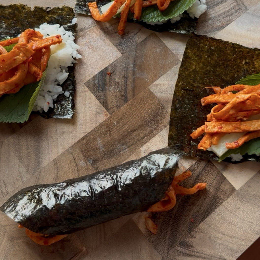 Homemade spicy Korean gimbap with savory fish cake and fresh perilla leaves
