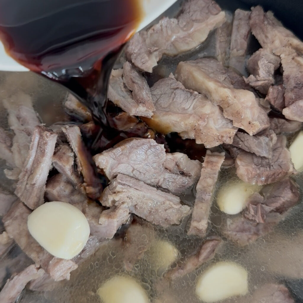 Adding soy sauce and seasonings to the beef